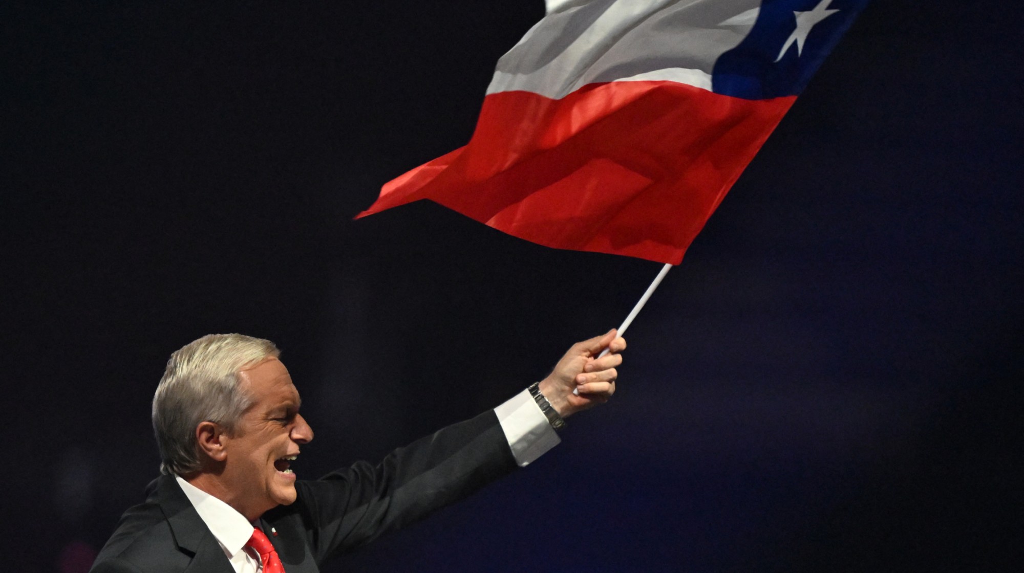 Chile's presidential candidate Jose Antonio Kast of the Republican Party waves a national flag during his closing campaign rally at Movistar Arena in Santiago on November 11, 2025. Chile will hold the presidential election on November 16, 2025. (Photo by MARVIN RECINOS / AFP) (Photo by MARVIN RECINOS/AFP via Getty Images)