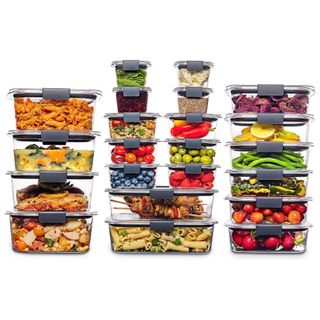 A set of 22 glass food storage containers filled with meal prepped meals, fruit and vegetables