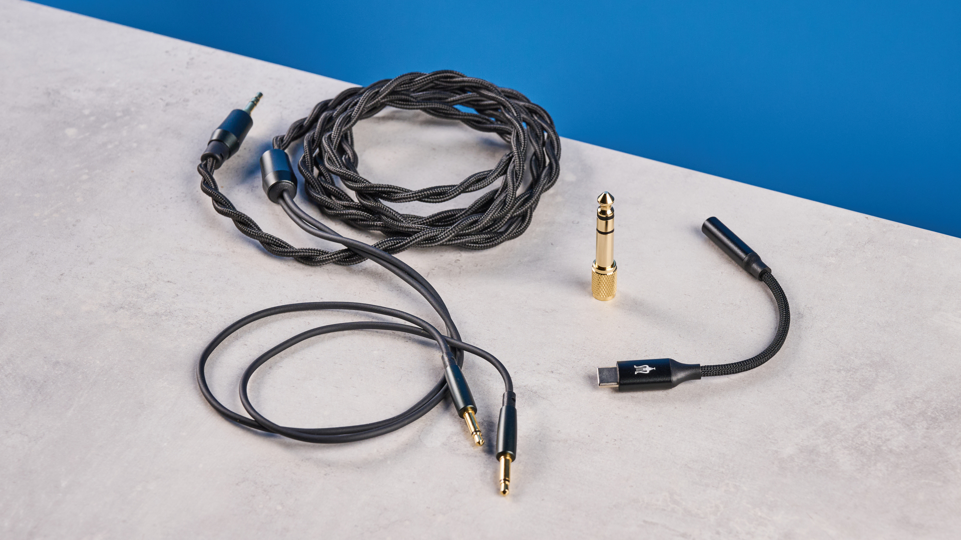 the meze 99 classics 2nd gen headphones with walnut finishes and gold touches against the blue tom&#039;s guide background