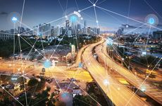 An abstract network graphic overlaid on an aerial view of a motorway network.