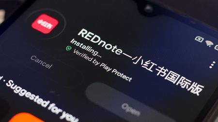 Rednote app being installed on a mobile phone.