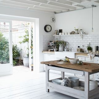 kitchen area with white wall and glass door and wooden floor