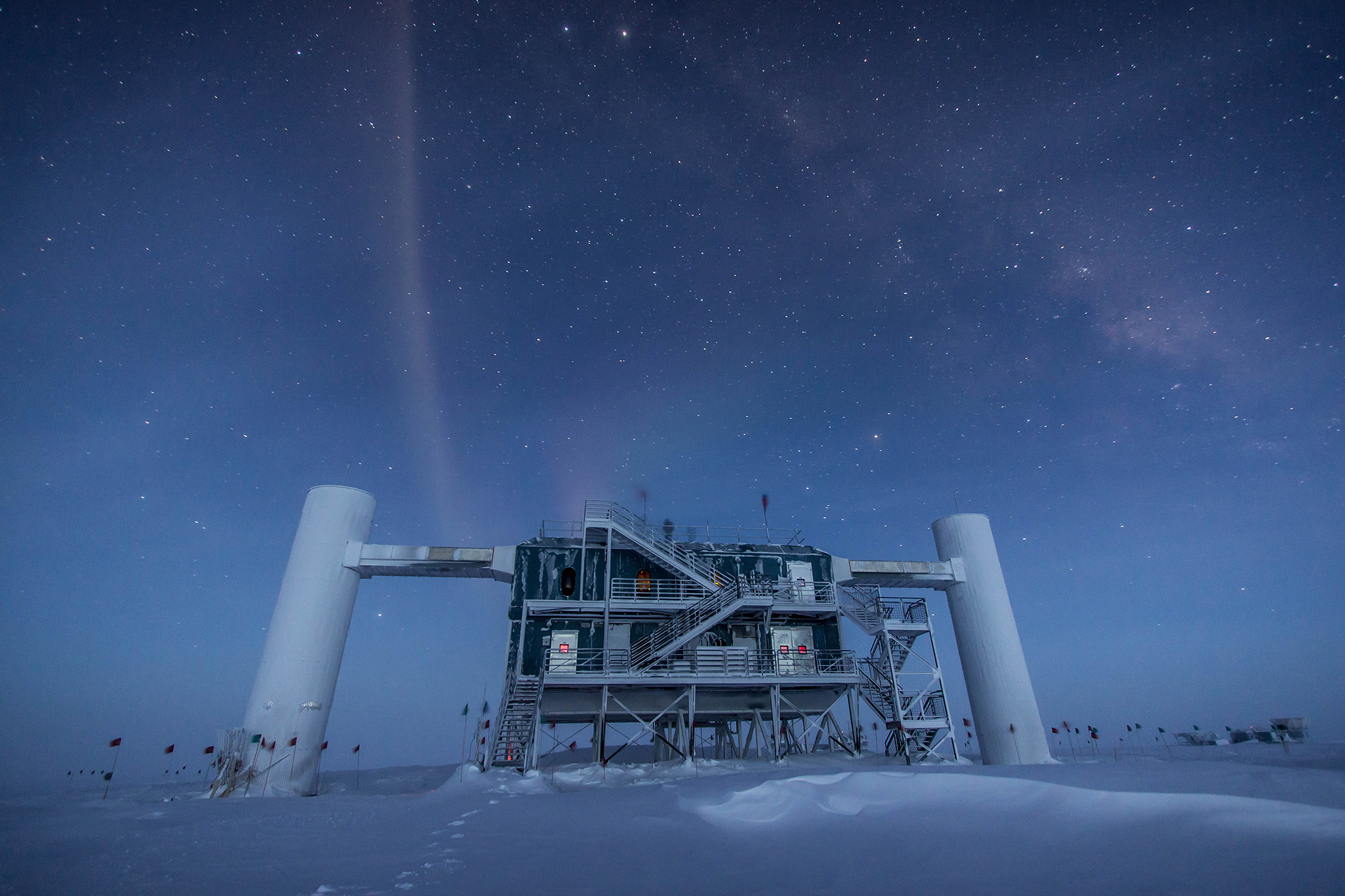 A towering research station stands under a star-studded sky in Antarctica.