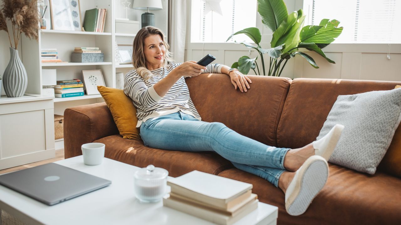 Woman watching TV with feet up on the sofa
