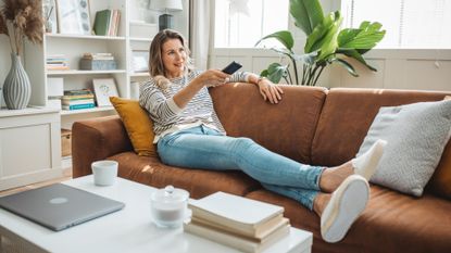Woman watching TV with feet up on the sofa