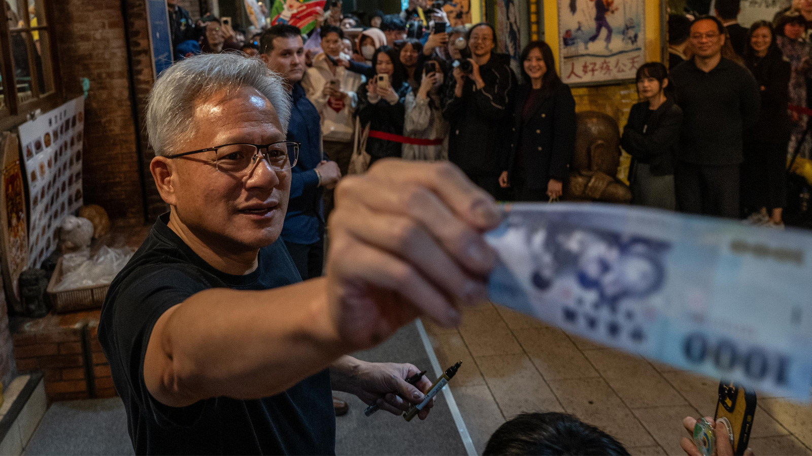 Jensen Huang feeding money off-screen.