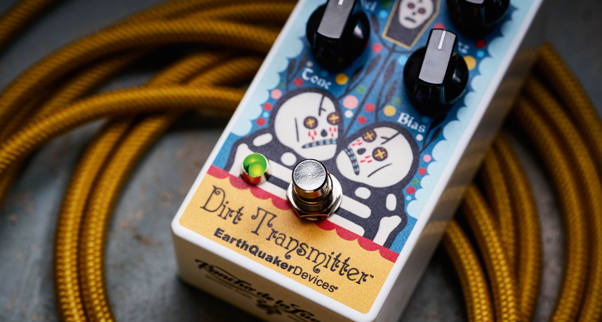 EarthQuaker Devices Rancho de la Luna Dirt Transmitter Fuzz Driver photographed on top of a tweed yellow guitar cable.