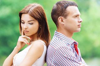 A man and woman with their backs facing each other, in deep thought.