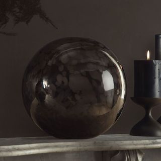 Spooky Glass Orb on a mantel against a black background.