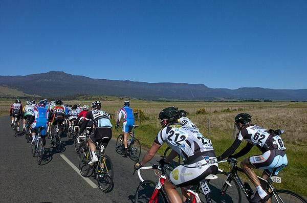Tasmanian Peter Loft (212) and Logan Calder (Plan B) from Western Australia relax at the back perhaps knowing what they were in for as the peloton approach the climb at Poatina in the background.