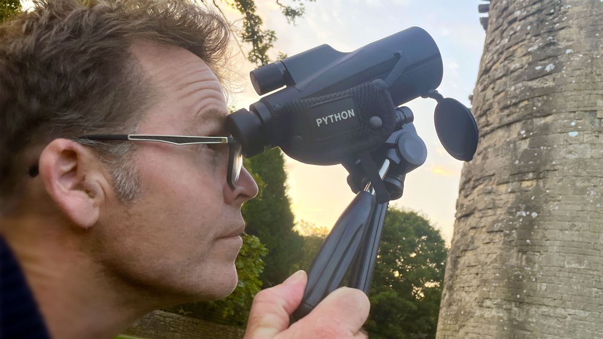 Monocular being used by the author outside a castle at sunset