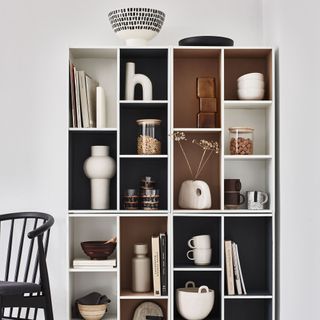 White shelving unit with interiors painted in shades of white, brown and black