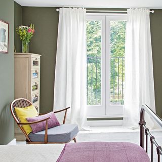 bedroom with wooden cupboard and white curtains
