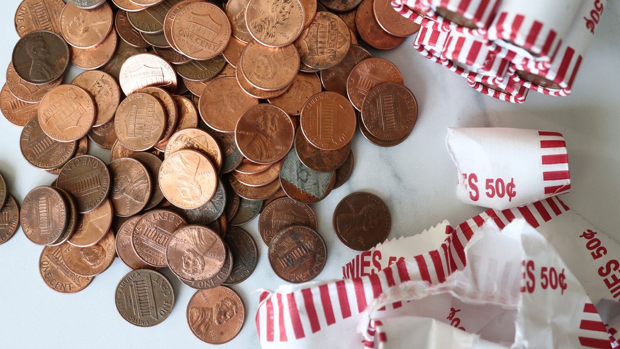 A pile of US one-cent &quot;pennies&quot; scattered on a white tabletop