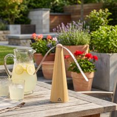 ALDI Ambiano Bug Repellant Fan on a garden table with a jug of lemonade