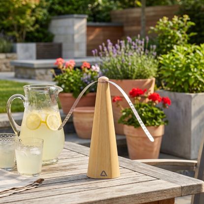 ALDI Ambiano Bug Repellant Fan on a garden table with a jug of lemonade