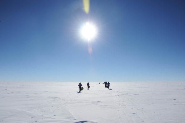 People walking on an ice sheet in Antarctica.