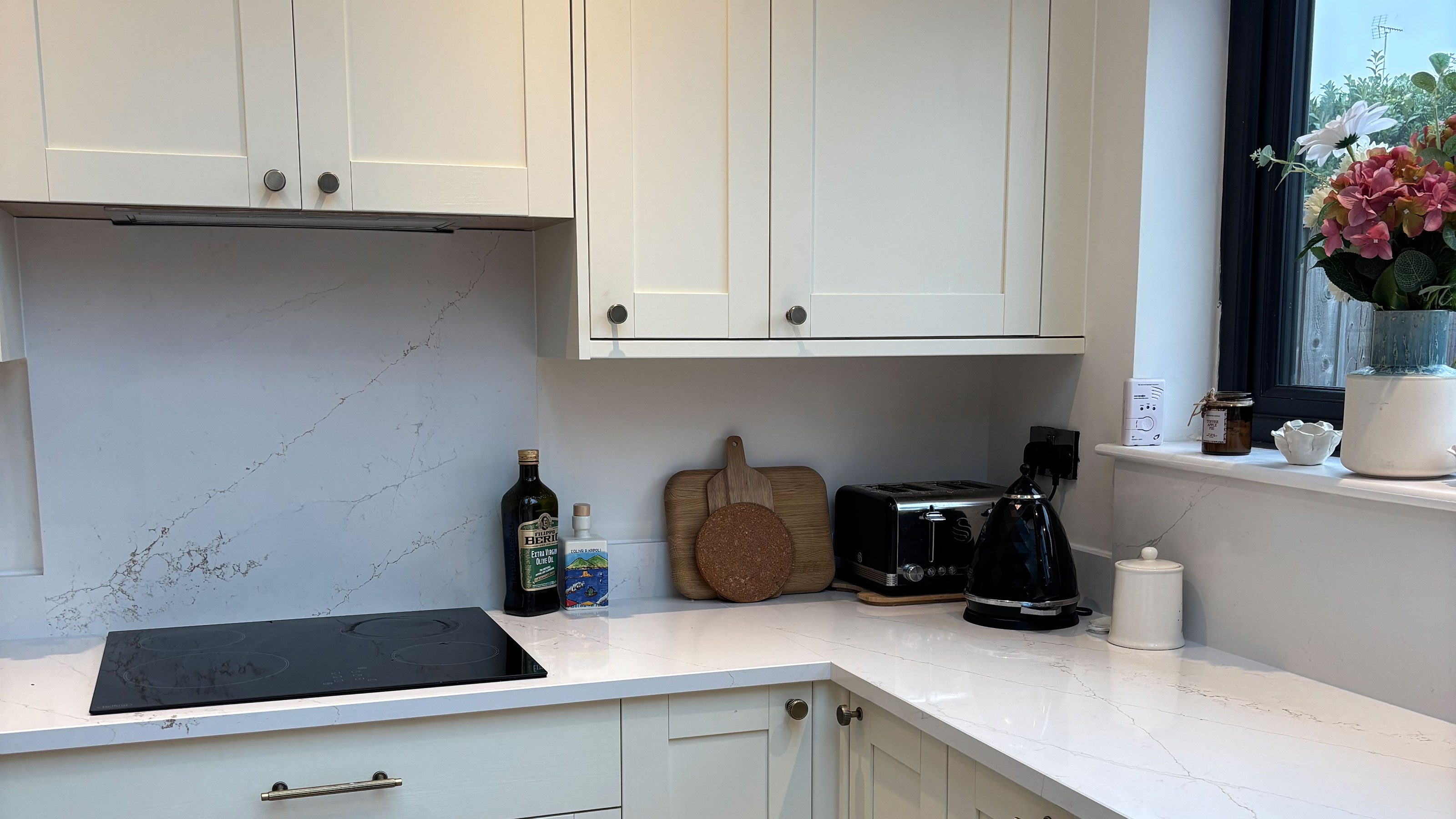 White kitchen with marble effect counter and splashback