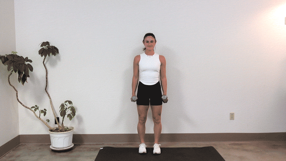 trainer Kirra Mitlo doing a dumbbell bicep curl into a shoulder press
