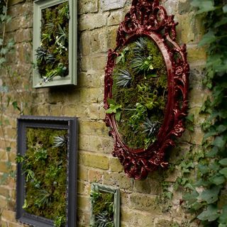 brick wall with green plant frames