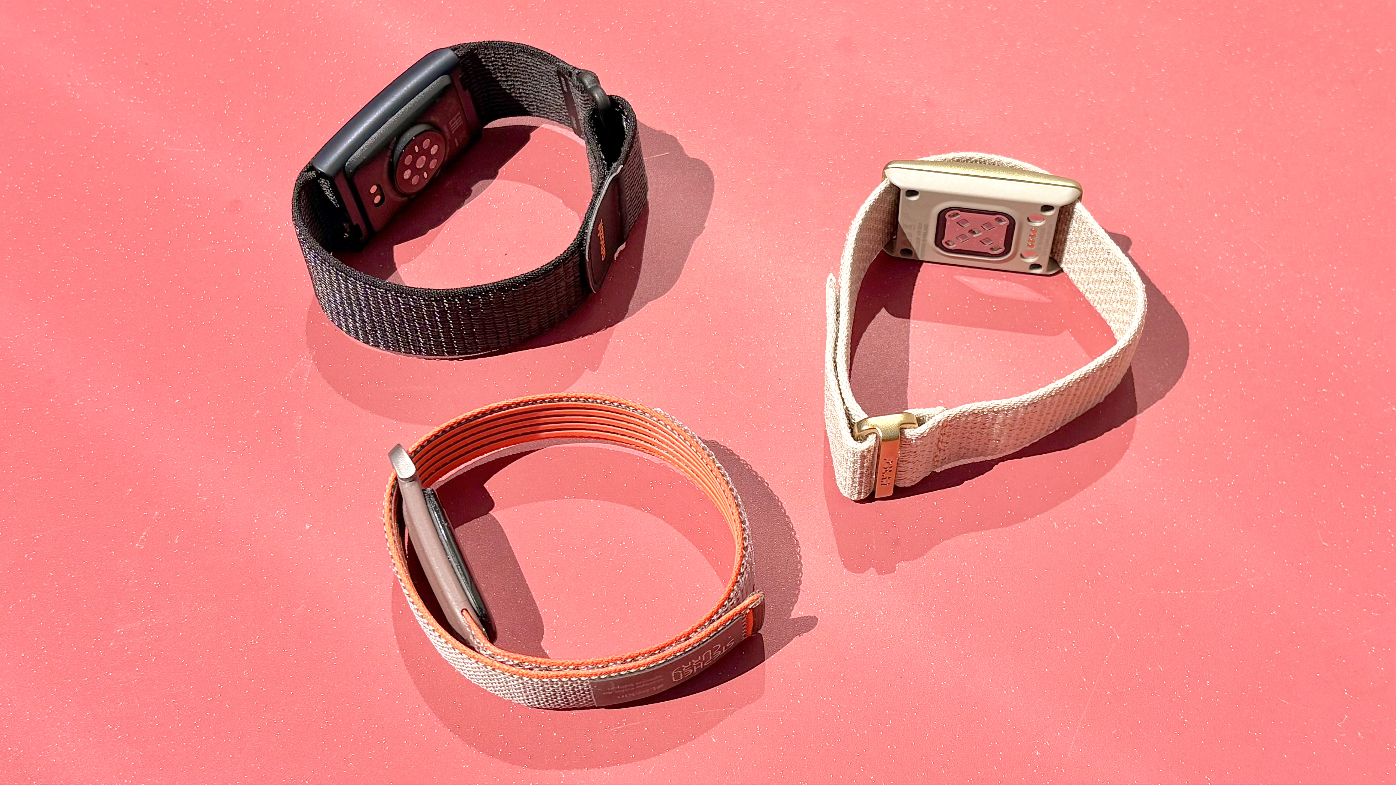 Close-up of the Fitbit Air, Polar Loop, and Amazfit Helio Strap