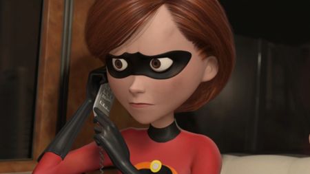 Mrs. Incredible holding a phone up to her left ear and looking concerned. 