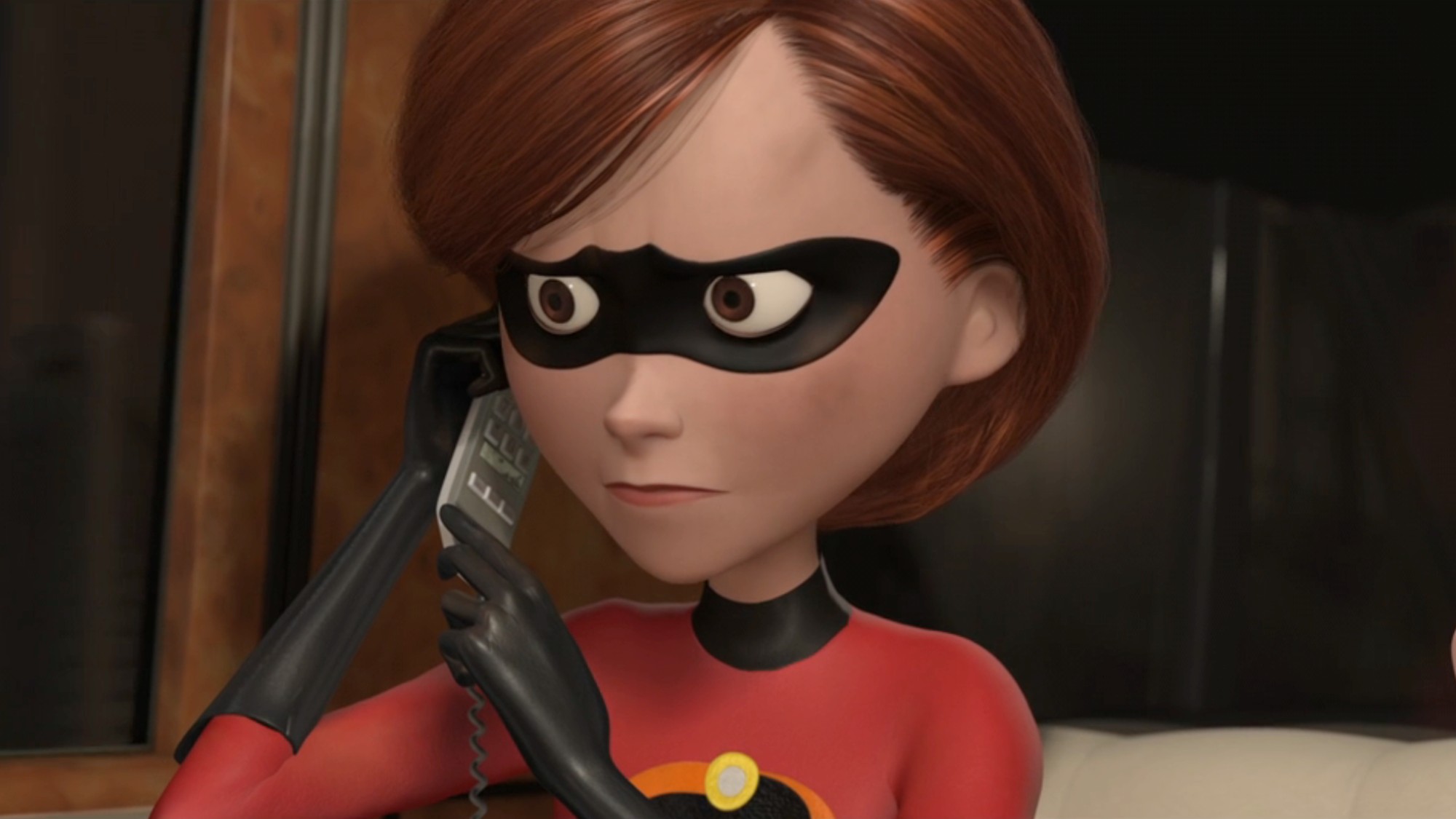 Mrs. Incredible holding a phone up to her left ear and looking concerned. 