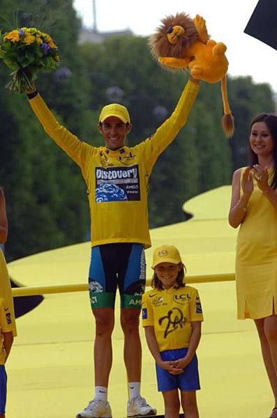 Alberto Contador isn't much bigger than the young podium assistant below him