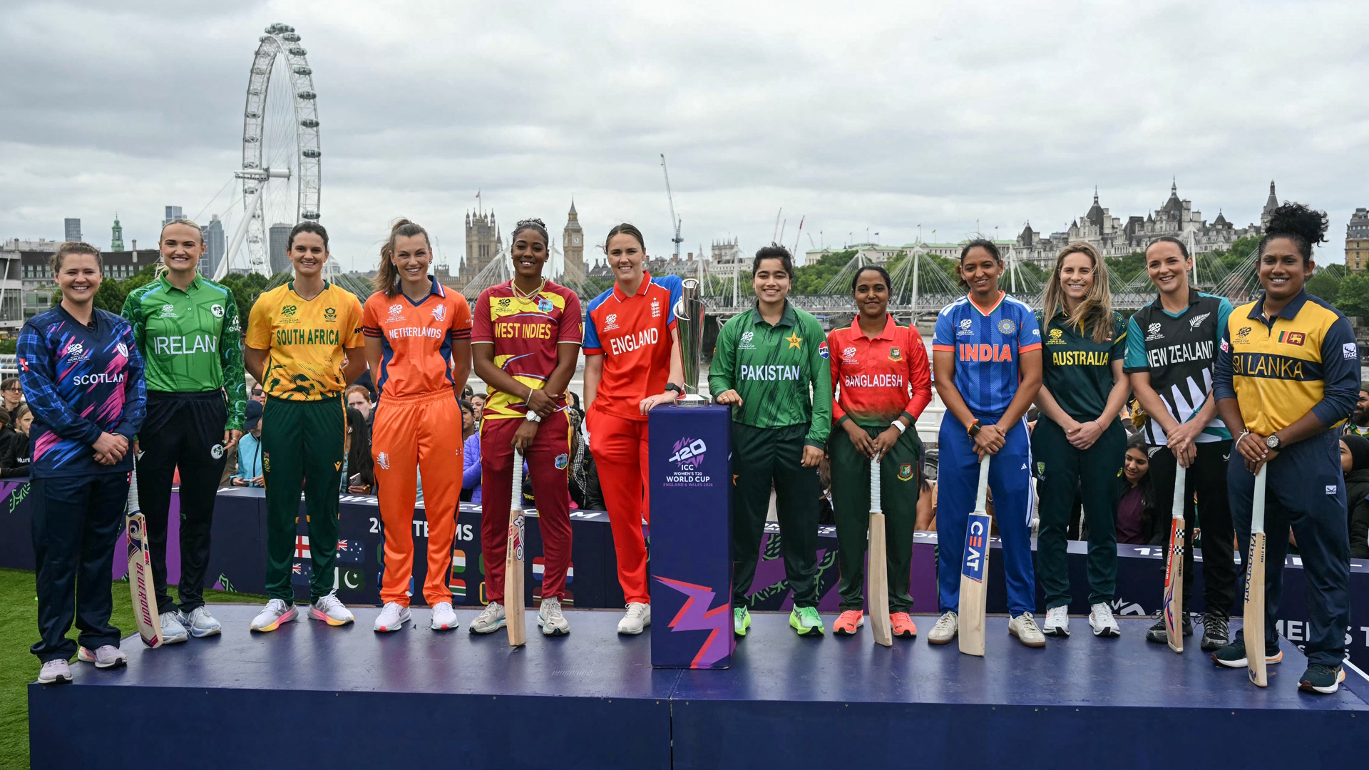 Team captains for each team pose together with the trophy in front of a London cityscape ahead of the Women's T20 World Cup 2026 cricket.