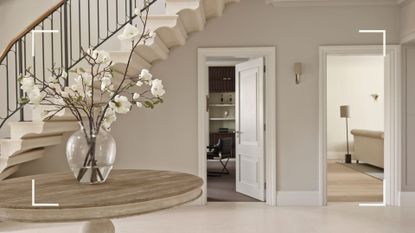 neutral entryway with wide spiral stairecase with views into rooms beyond to support an article on how to clean walls without damaging paint