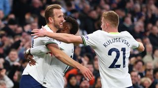 Harry Kane celebrates with Emerson Royal and Dejan Kulusevski after scoring for Tottenham against Manchester City and becoming Spurs' all-time top scorer.