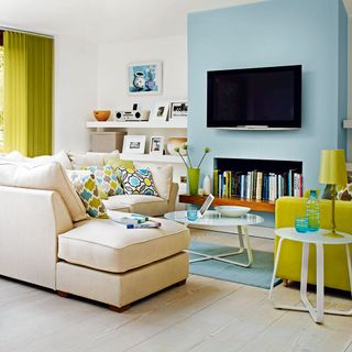 living room with L shaped sofa blue walls and tv unit