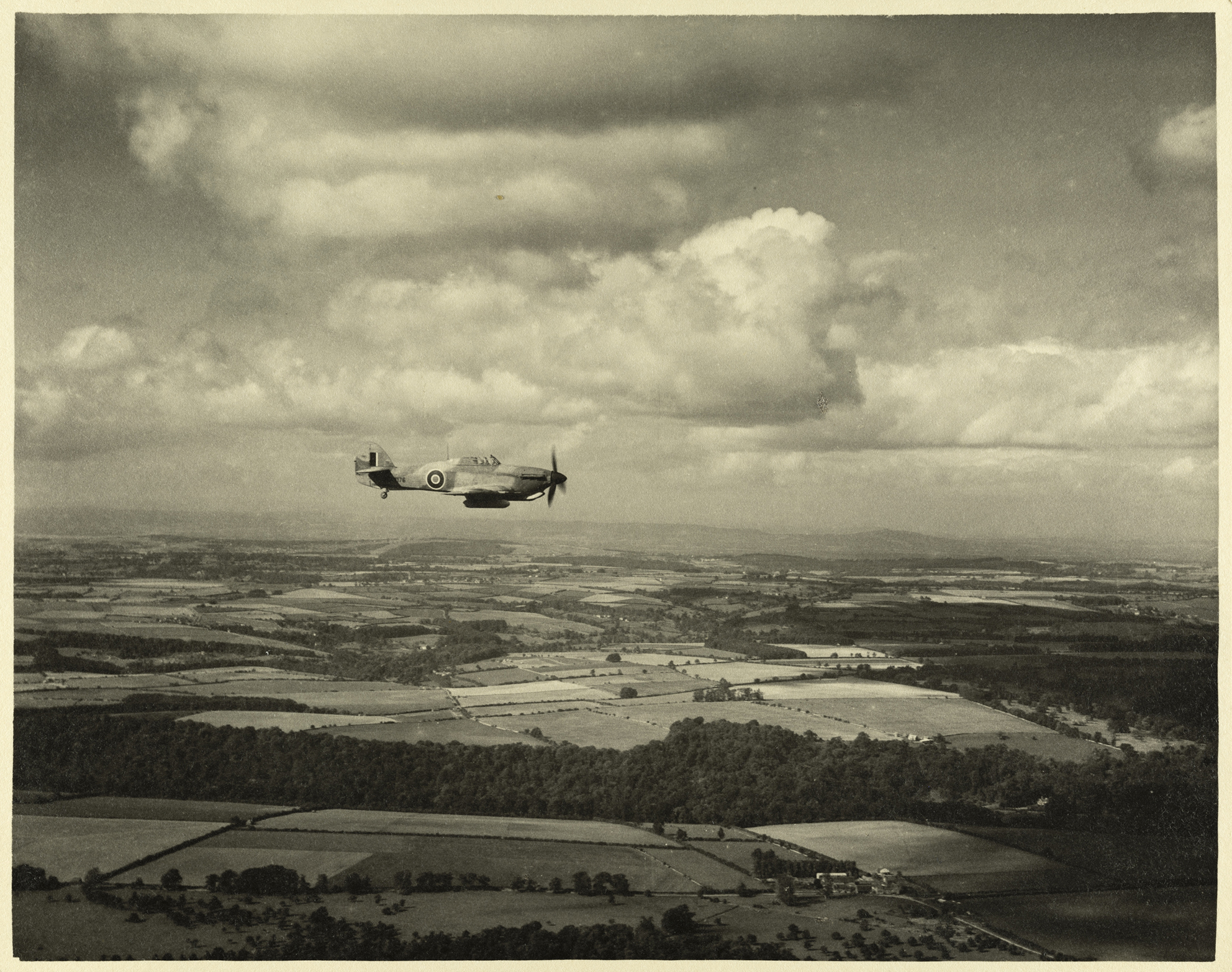 Still from a film produced by the RAF Film Production Unit during the Second World War, showing a 'hurribomber' - a fighter bomber variant of the Hawker Hurricane - in flight