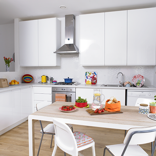 kitchen with wooden flooring and white cabinets and dining table