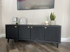 Black cabinet with fluted doors and gold handles 
