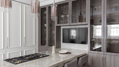 A kitchen with white cupboards and a quartzite-topped breakfast bar