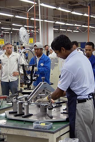 A Shimano employee carefully mates the rim