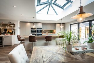 an open plan kitchen with a dining room and bar area