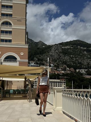 Eliza Huber wearing a white sleeveless Zara top with Prada shorts at the Monte-Carlo Bay Hotel in Monaco.