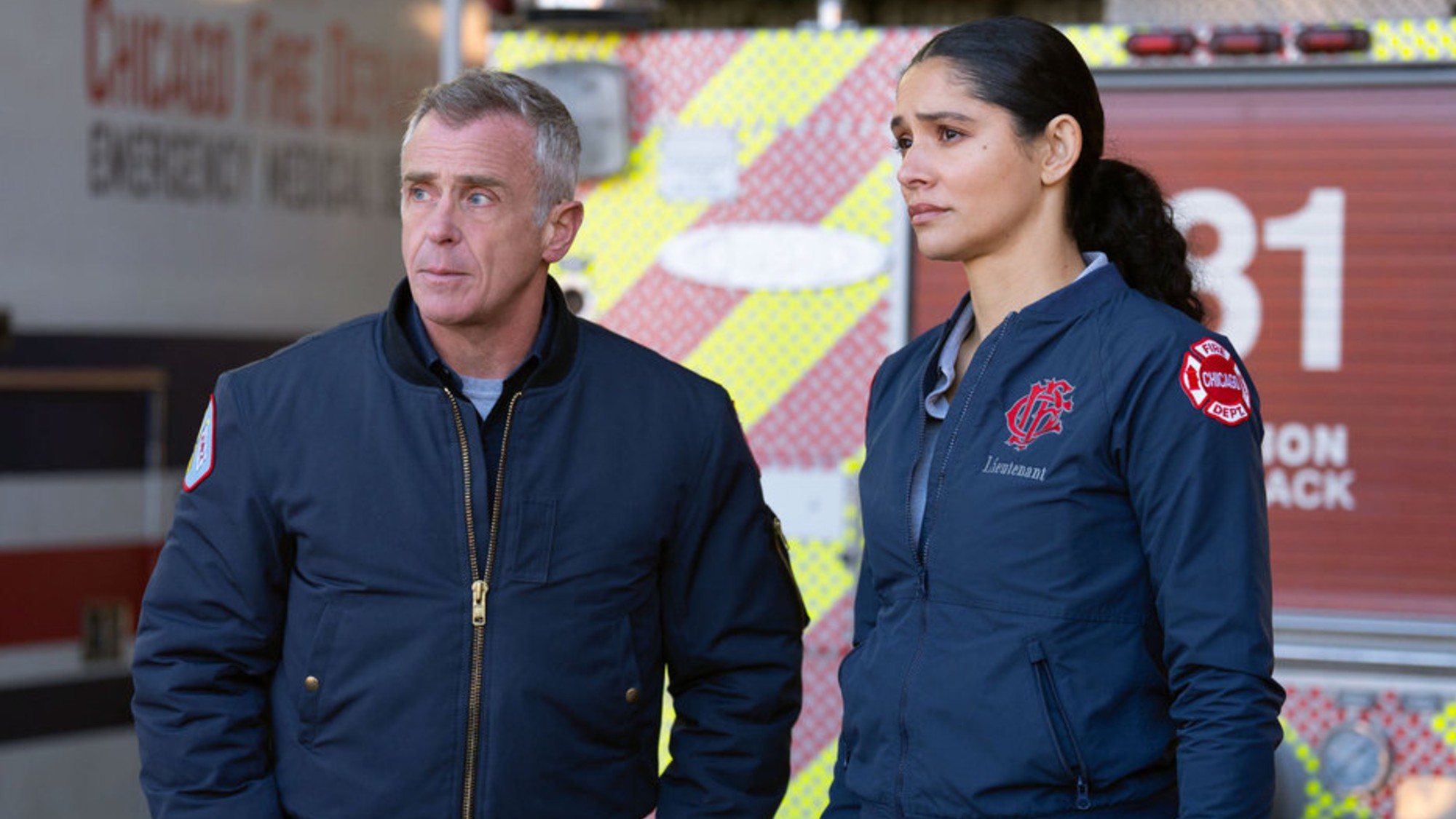 Hermann and Kidd standing next to each other in front of the firetruck on Chicago Fire.