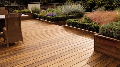 newly stained deck with planters and garden furniture