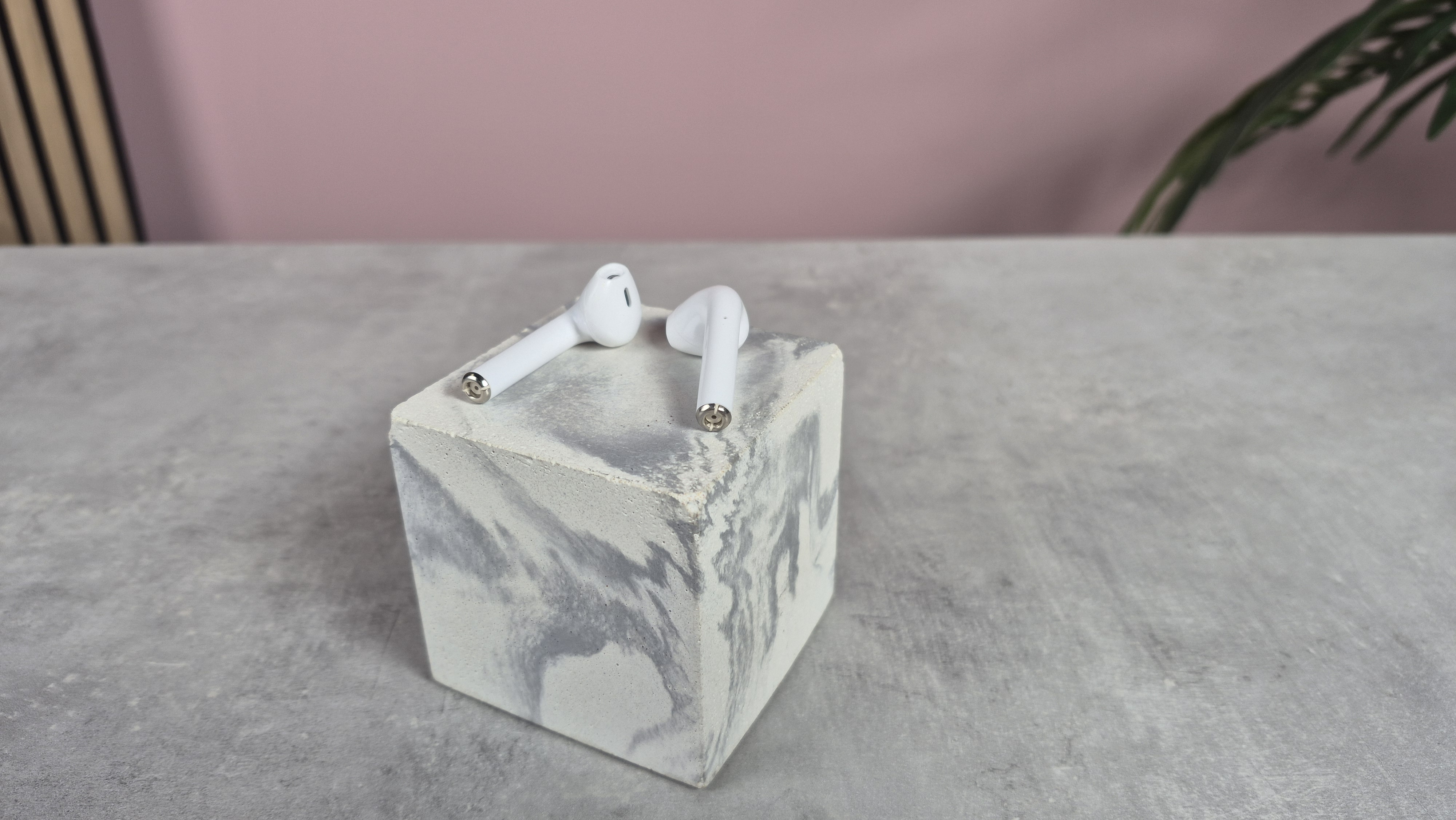 Cheap wireless earbuds balanced on top of block