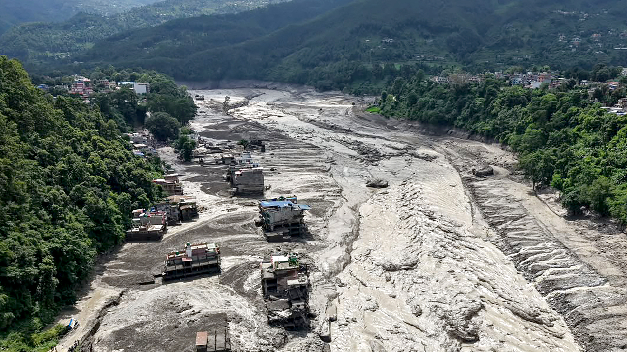 Houses lie partially submerged in muddy water along a riverside after flash floods at Trishuli Bazar in Nepal's Nuwakot district.