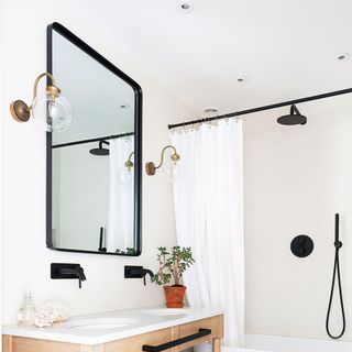 bathroom with white wall mirror wash basin and wall lamp