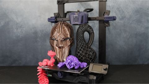 Assorted 3D printed objects next to the Anycubic Kobra Neo 3D printer