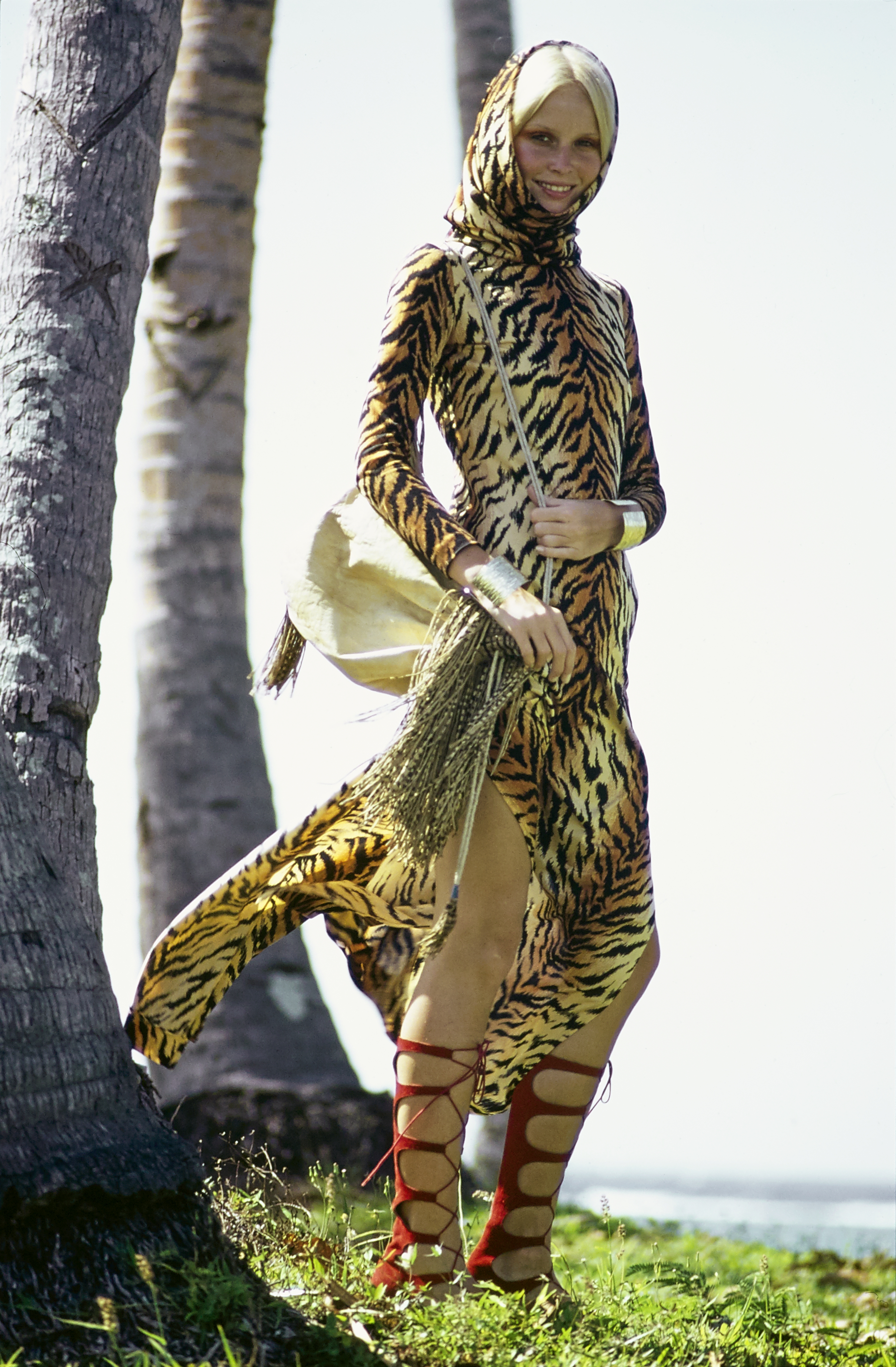 Model Gunilla Lindblad stands on the island of Fiji. She is wearing a Ban-Lon tiger print hooded robe by Scott Barrie for Barrie Sport, in Antron nylon; print designed by Gilbert Frank. Styled with a bag by Moroccan Fashion &amp;amp; Arts, Battani Boutique tall red sandals, and gold cuffs from Thomas Robbins for Tortolani-Crislu. *** Local Caption *** Gunilla Lindblad;