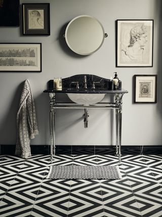 black and white geometric floor tiles, black marble vanity, grey walls, artwork