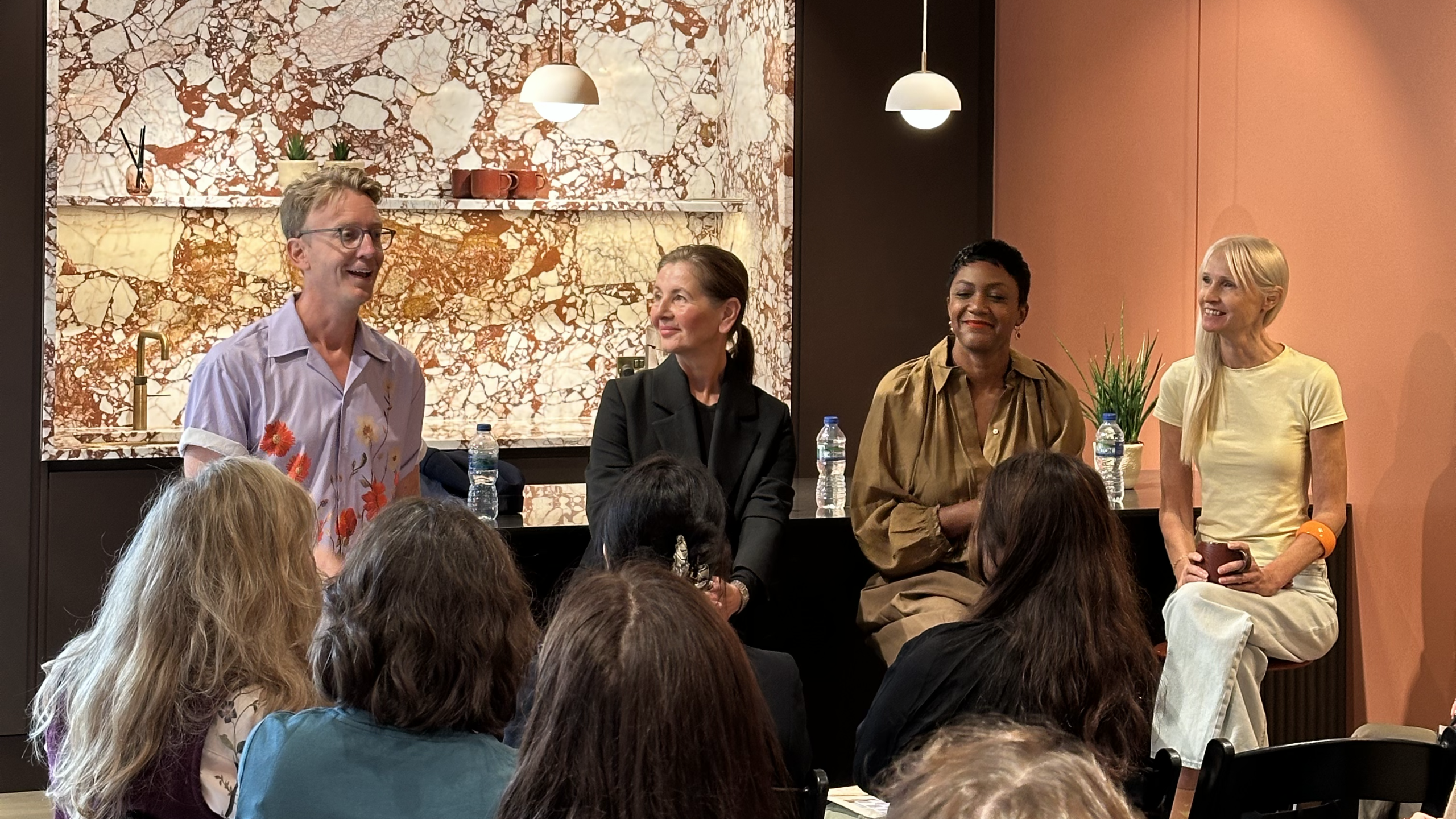Pip Rich, Cassandra Ellis, Alex Dauley and Karen Haller on high stools addressing an audience