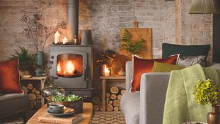 picture of cosy living room with log burner and stores of wood around