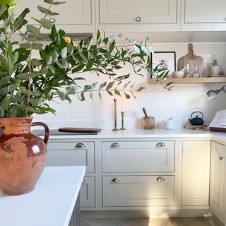 kitchen area with white kitchen cabinet and pot